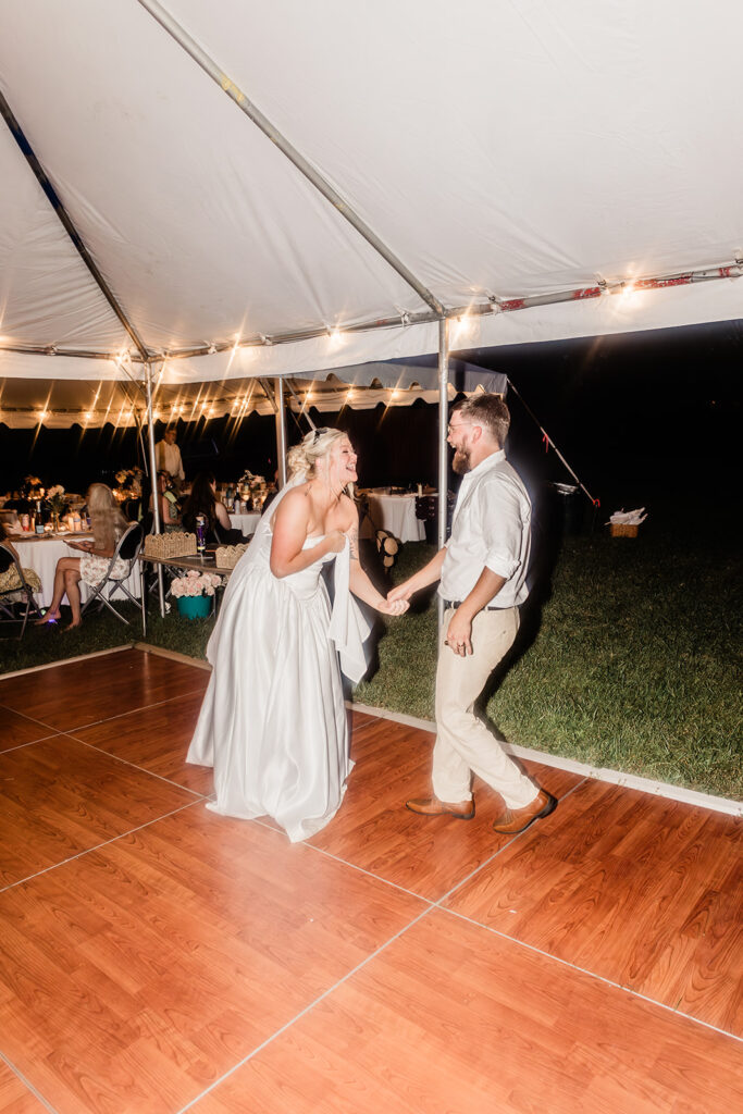 bride and groom laughing and dancing